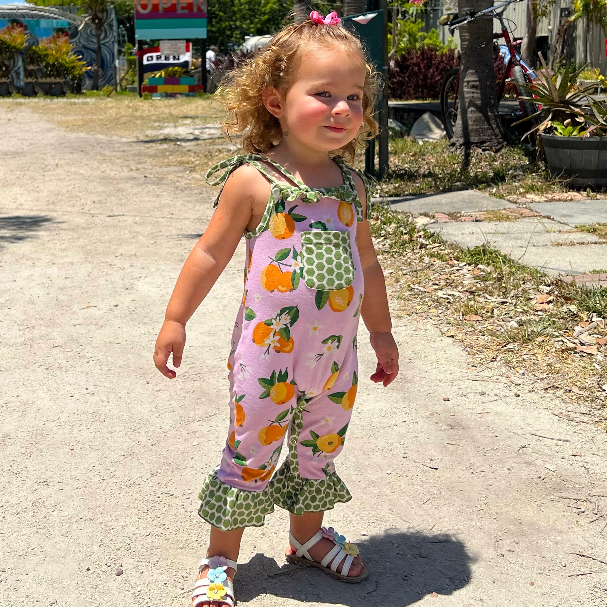 AnnLoren Pink Peach Baby Toddler Girls Spring Romper with green polka dot pocket and ruffle trim, perfect for spring outings.